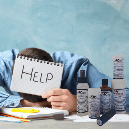 Man exhausted at desk holding a help sign with Burnout Reset Kit products for natural stress relief